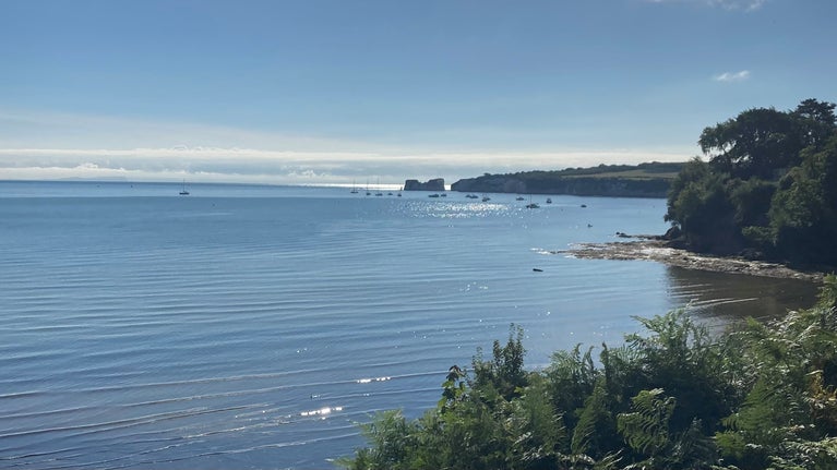 View from cliff top at Middle Beach with sparkling blue water and clear blue sky.